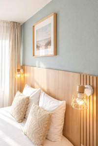 Applique en forme de lanterne et coussins au-dessus d’un lit