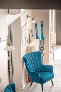 Hall d’entrée de l’hôtel Le Rivage avec un fauteuil bleu canard
